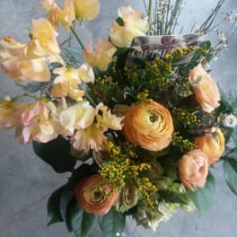 Bouquet of peach flowers with orange ranunculus and yellow accents