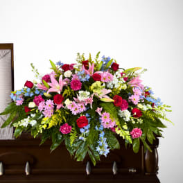 Large floral casket spray with roses, lilies, and mixed blooms