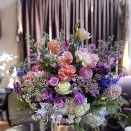Mixed bouquet of pink, purple, and white flowers in a metallic vase