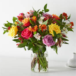 Mixed bouquet of roses and alstroemeria in a clear glass vase