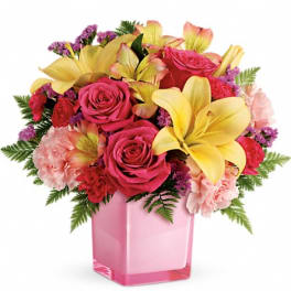 Pink roses and yellow lilies in a pink glass vase