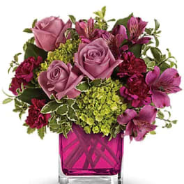 Pink and purple bouquet in a magenta glass vase