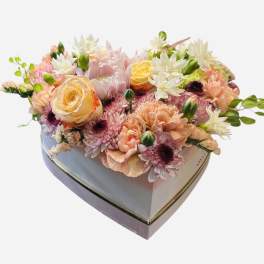Heart-shaped box filled with pastel mixed flowers