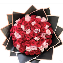 Bouquet of red and pink roses wrapped in black paper