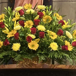 Large basket arrangement of red roses and yellow daisies