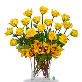 Tall arrangement of yellow roses and yellow orchids in a clear glass rectangular vase