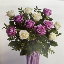 Bouquet of purple and white roses in a tall purple vase