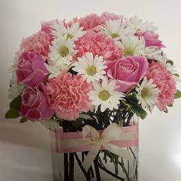 Pink roses and carnations with white daisies in a clear glass vase