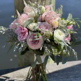 Pink and white bouquet of roses and ranunculus with greenery