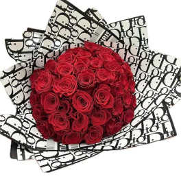 Bouquet of red roses wrapped in black-and-white patterned paper