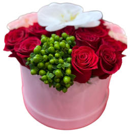 Red roses in a pink hatbox with white and pink accents