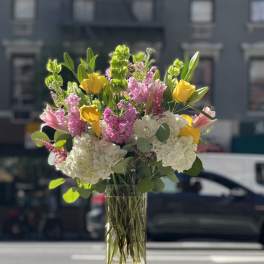 Bouquet of pink, white, and yellow flowers in a clear glass vase