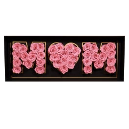 Pink roses arranged to spell "MOM" in a black shadow box.