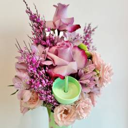 Pink rose bouquet with peach blooms in a decorated cup holder