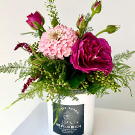 Pink and magenta roses with a pale pink zinnia in a white container