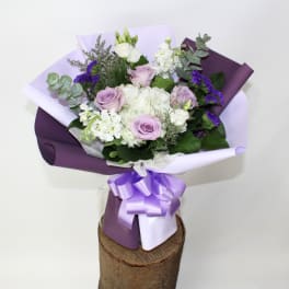 Bouquet of lavender and white flowers wrapped in purple paper