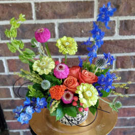 Colorful mixed flower arrangement in a patterned container