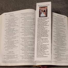 Bible open to Psalms with a memorial bookmark laid across the pages