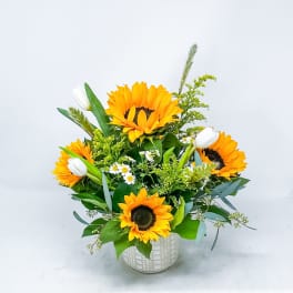 Sunflower bouquet in a white patterned vase with white tulips
