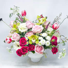 Mixed bouquet of pink and white flowers in a white vase
