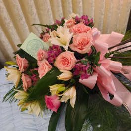 Bouquet of pink roses and white lilies with a pink ribbon