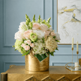Cream and blush rose arrangement in a gold vase