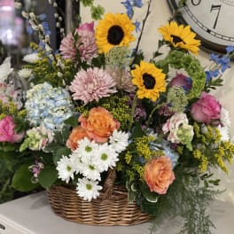 Mixed flower basket with sunflowers, roses, daisies, and hydrangeas