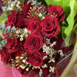 Bouquet of red roses wrapped in bright green paper