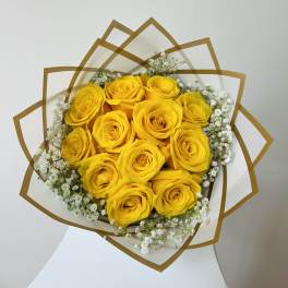Bouquet of yellow roses with white baby's breath in decorative wrap