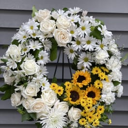 Heart-shaped floral wreath with white roses, daisies, and yellow sunflowers