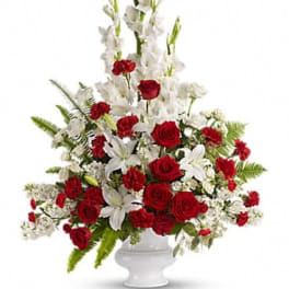 Red roses and white lilies in a white pedestal vase