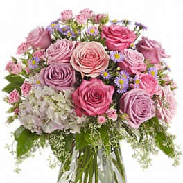 Pink and lavender roses in a glass vase with small purple flowers