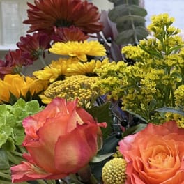 Mixed bouquet with orange roses, yellow chrysanthemums, and red blooms
