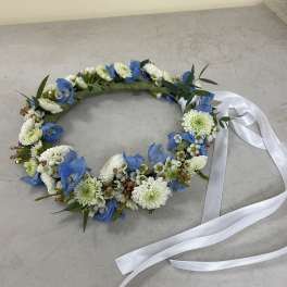 Blue and white floral wreath with a white ribbon
