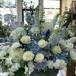 Large basket arrangement of white, blue, and lavender flowers