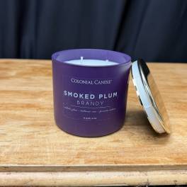 Purple scented candle in a glass jar with a metal lid