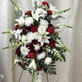 Tall standing floral spray with white lilies, chrysanthemums, and red carnations