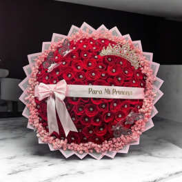 Round bouquet of red roses with a pink ribbon and crown decoration
