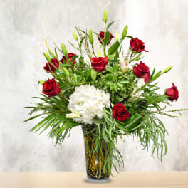 Red roses and white hydrangea in a glass vase