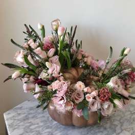 Pink floral arrangement in a pumpkin-shaped vase