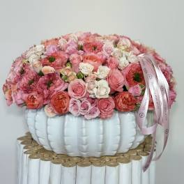 Pink and white rose arrangement in a white pumpkin-shaped vase with ribbon