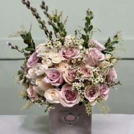 Bouquet of blush and white roses in a gray hatbox