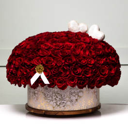 Large dome of red roses in a decorative round box with white heart toppers