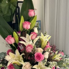 Pink roses and white lilies arranged in a large bouquet