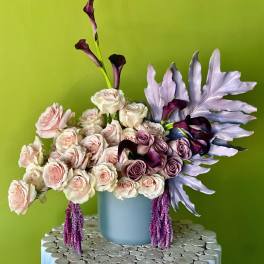 Bouquet of pale pink and lavender roses in a blue vase