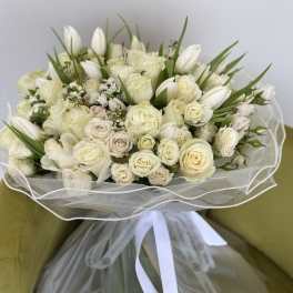 Cream rose and white tulip bouquet wrapped in sheer paper