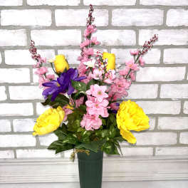 Mixed pink and yellow flowers in a tall green vase