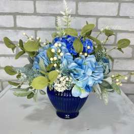 Blue and white floral arrangement in a cobalt glass vase