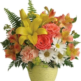 Mixed bouquet in a speckled yellow vase with lilies, roses, daisies, and alstroemeria