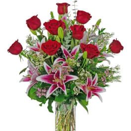 Red roses and pink lilies arranged in a clear glass vase